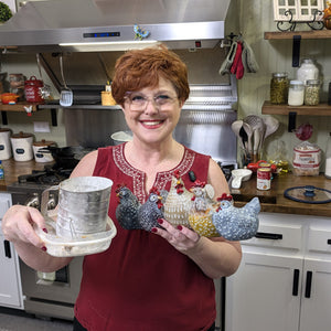Tammy Nichols in her kitchen holding a sifter and ceramic hens
