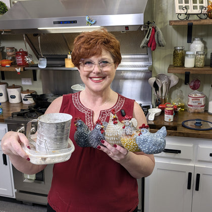 Tammy Nichols in her kitchen holding a sifter and ceramic hens
